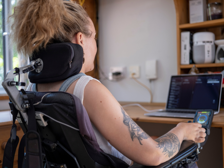 Woman in electric wheelchair working on laptop