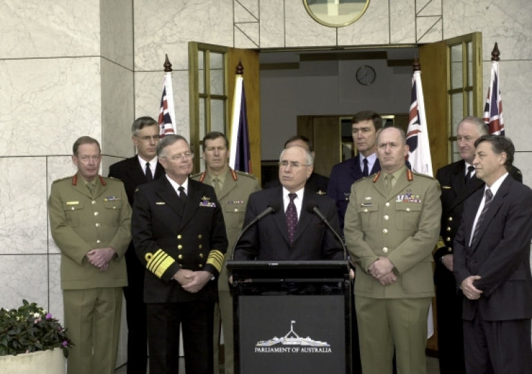 John Howard stands behind podium