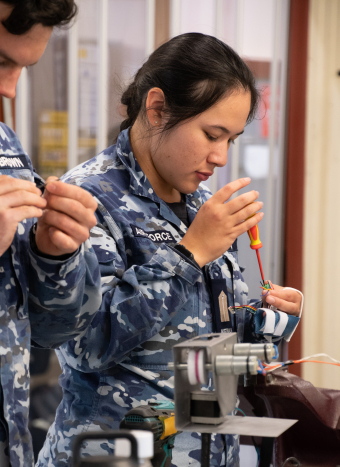 Engineering student in an Air Force uniform works on her project. 