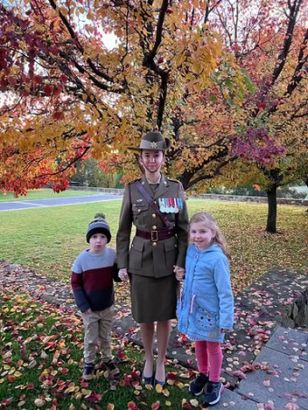 MAJ Lyndsay Freemans stands in front of tree with son and daughter. 