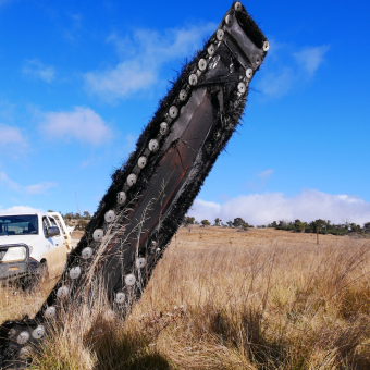 A piece of space junk stands tall in field of grass